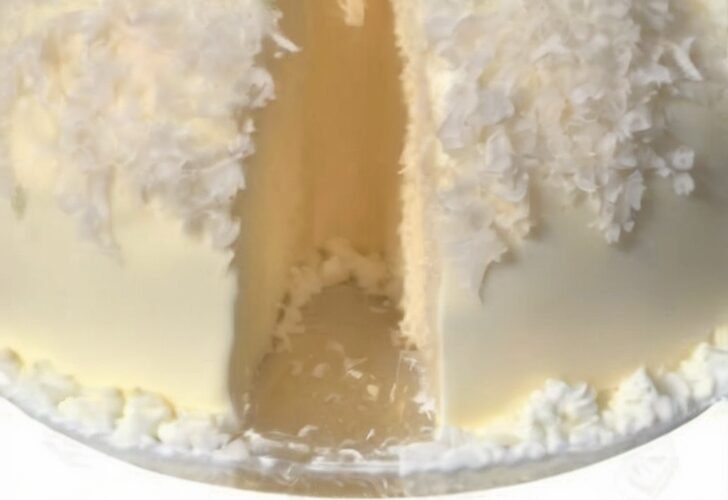 Catch a Husband Cake, a moist white coconut cake topped with fluffy shredded coconut and creamy frosting, shown with the recipe ingredients below.
