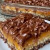 Chocolate caramel pretzel bars with a crunchy pretzel crust, chewy caramel layer, and smooth chocolate topping, cut into rich dessert squares.