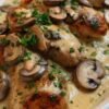 Creamy garlic mushroom chicken topped with sautéed mushrooms and fresh parsley, served in a rich, savory cream sauce.