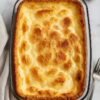 Golden, fluffy 3-ingredient baked breakfast casserole served in a glass baking dish, with a lightly browned top and soft, airy center.