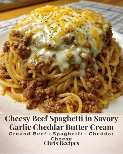 A hearty plate of cheesy beef spaghetti coated in a rich, creamy garlic-cheddar sauce, topped with seasoned ground beef and a generous layer of melted cheese