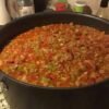 A hearty pot of homemade beef chili loaded with ground beef, beans, tomatoes, onions, and colorful green peppers in a rich, savory tomato-based sauce.
