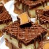 Decadent Rolo cheesecake bars with a buttery graham cracker crust, creamy cheesecake center, rich chocolate topping, and Rolo candies with gooey caramel centers on top.