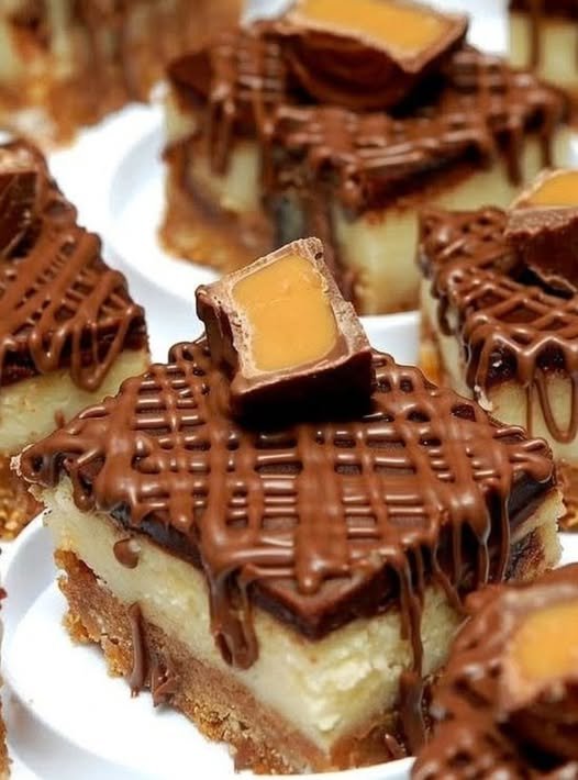 Decadent Rolo cheesecake bars with a buttery graham cracker crust, creamy cheesecake center, rich chocolate topping, and Rolo candies with gooey caramel centers on top.