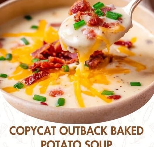 A creamy loaded baked potato soup topped with melted cheddar cheese, crispy bacon pieces, and fresh green onions, with a spoonful being lifted to show its rich, velvety texture.