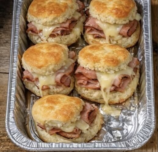 Golden, buttery biscuit sandwiches stuffed with deli ham and gooey melted Swiss — baked all together in one pan