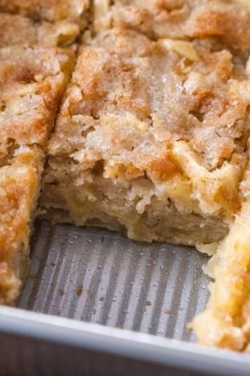 Golden-brown crumb cake bars with a buttery, tender center and a crisp, lightly caramelized topping, baked in a rectangular pan and cut into squares.