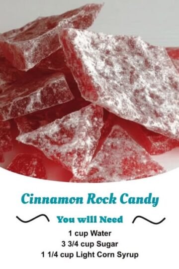 A pile of glossy red cinnamon rock candy pieces dusted generously with powdered sugar, with a crisp, glass-like texture and a sweet, spicy cinnamon flavor