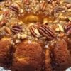 A rich, moist pecan Bundt cake coated in glossy caramel glaze and generously topped with toasted pecans, creating an irresistible buttery, crunchy finish.