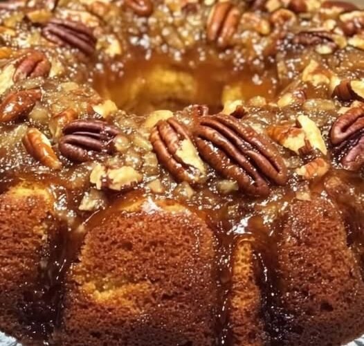 A rich, moist pecan Bundt cake coated in glossy caramel glaze and generously topped with toasted pecans, creating an irresistible buttery, crunchy finish.