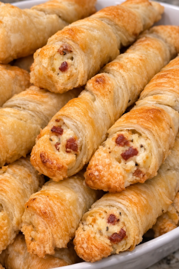 Crisp, flaky puff pastry twisted around a warm, savory ham and cheddar filling — a 1965 classic that empties the platter every time.