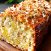 Soft banana bread with sweet pineapple pockets, chewy coconut, and a toasted golden top — sunshine in bread form.