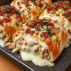 Stuffed breadstick bombs made from leftover rotisserie chicken, creamy Alfredo, and melted mozzarella, topped with garlic butter and crumbled bacon. Bakes golden in one 9x13 dish and freezes unbaked for later.