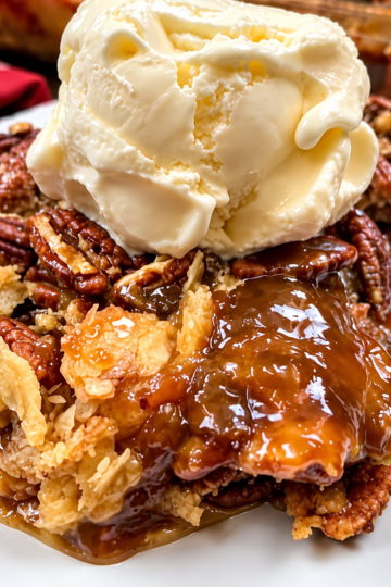 A buttery golden cake layer over melted butter and pecans, with a glossy brown sugar caramel sauce in the bottom of the dish. Eight ingredients, one pan, no frosting, and it feeds twelve for about 54 cents a scoop.