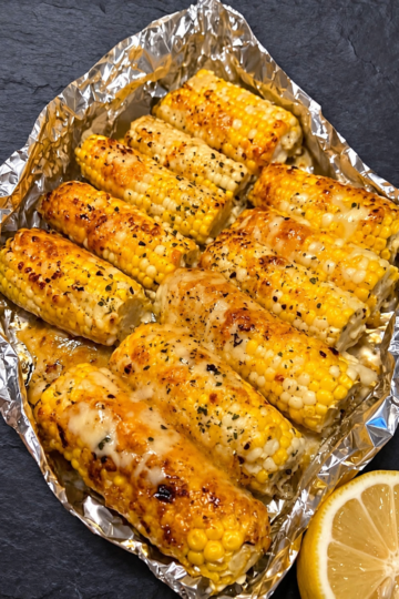 Grilled corn cobs slathered in creamy, tangy crema with salty cotija cheese, chili, cilantro, and a bright squeeze of lime. Authentic street-food energy for your backyard or kitchen — naturally gluten-free and vegetarian.