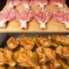 Golden roasted butterflied chicken drumsticks arranged over tender potato wedges in a baking pan, with crispy caramelized edges and a savory seasoned coating.