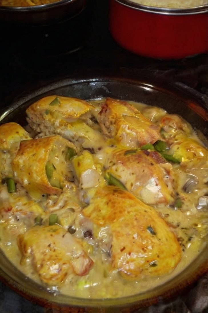 Golden-browned chicken legs smothered in a rich creamy mushroom sauce with sliced mushrooms, garlic, and herbs, served hot in a glass baking dish.