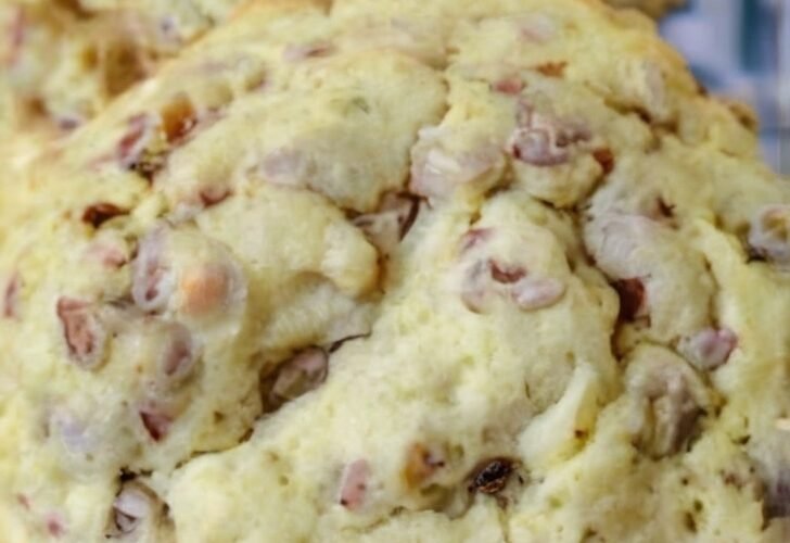 A stack of thick, soft-baked toffee pecan cookies with lightly golden edges, crumbly centers, and generous pieces of buttery toffee and chopped pecans throughout.