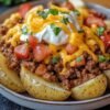 Crispy baked potatoes loaded with seasoned ground beef, melted cheddar cheese, creamy sour cream, diced tomatoes, and fresh cilantro