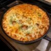 A bubbling baked cream cheese spaghetti casserole topped with golden, melted mozzarella and Parmesan, sprinkled with fresh parsley and baked until beautifully browned around the edges.