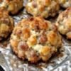 Golden-brown baked meatballs with a crisp, savory exterior and tender, juicy centers, arranged on a foil-lined baking sheet.
