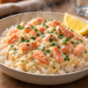 Alt text: Creamy salmon chunks in a rich, velvety white sauce served over fluffy white rice, garnished with fresh parsley and accompanied by a lemon wedge for a bright, fresh finish.