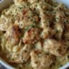 A comforting bowl of creamy chicken pasta featuring tender, golden-browned chicken pieces coated in a rich garlic-Parmesan sauce, tossed with pasta and finished with fresh chopped parsley