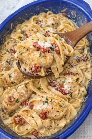 Creamy Tuscan-style chicken pasta with tender chicken, fettuccine, sun-dried tomatoes, Parmesan, and fresh herbs tossed in a rich, velvety garlic cream sauce.