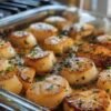 Golden-browned baked scallops seasoned with herbs and black pepper, resting in a rich buttery pan sauce and finished with a lightly caramelized crust