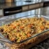 A hearty baked spaghetti casserole loaded with tender noodles, seasoned ground beef, peas, and diced carrots, all tossed in a savory sauce and baked together for a comforting family-style meal.
